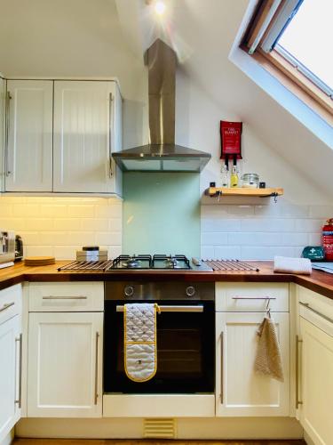 a kitchen with a stove top oven in a kitchen at Pinnacle Apartment in Reading