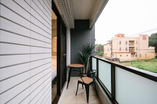 a balcony with two chairs and a table at Shishi Homestay in Wujie