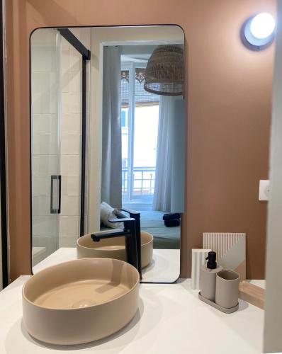 La salle de bains est pourvue de 2 toilettes et d'un grand miroir. dans l'établissement Appartement hausmannien au coeur du 7e, à Lyon