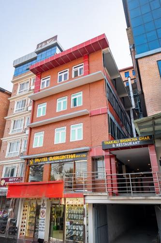 a tall building with a store in front of it at OYO 825 Hotel Baikuntha in Kathmandu