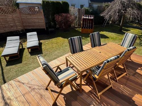 Neuhausにある-"Ferienwohnung Dierhagen" Whg 1 im EG-のデッキの上の木製のテーブルと椅子