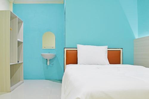 a bedroom with a white bed and a sink at Collection O Balikpapan Near Balikpapan Super Block Formerly City Inn Hotel in Balikpapan