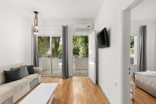 a living room with a couch and a tv at Mr and Mrs White Corfu Couples Retreat Adults Only in Acharavi