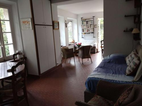 une chambre avec un lit, une table et des chaises dans l'établissement Studio vue mer et jardin à deux pas du centre du village, à Porquerolles