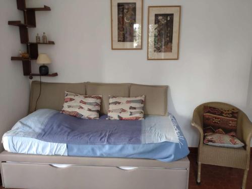 - un lit avec des draps et des oreillers bleus dans une chambre dans l'établissement Studio vue mer et jardin à deux pas du centre du village, à Porquerolles
