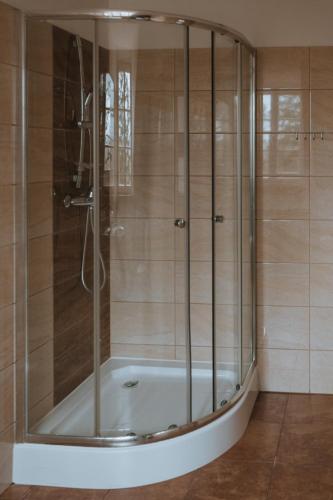 a bathroom with a shower with a bath tub at Pokoje Gościnne Domu Pielgrzyma w Supraślu in Supraśl