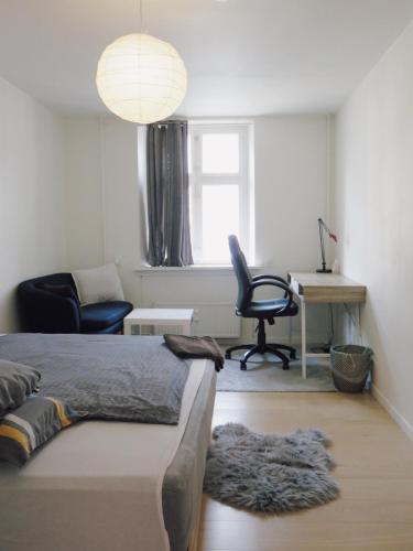 a bedroom with a bed and a desk and a chair at close to norreport st & central 302 - norregade 34a 3 kobenhavn 1165 in Århus Østbanegård