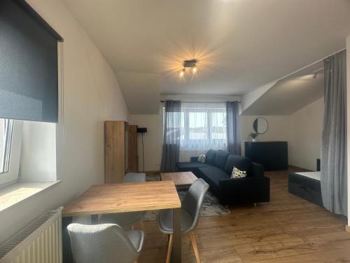 a living room with a table and a couch at Apart Izabelinska in Stanisławów Pierwszy