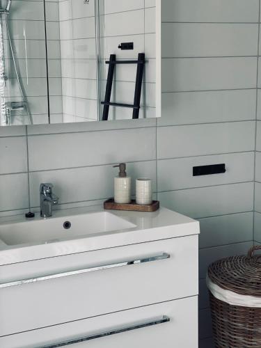 a white bathroom with a sink and a mirror at No7 Risør in Risør