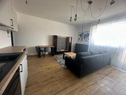 a living room with a couch and a table at Apart Izabelinska in Stanisławów Pierwszy