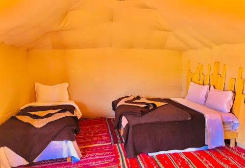 a room with two beds in a tent at Guesthub camp in Merzouga