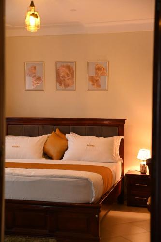 a bedroom with a large bed with white pillows at Hotel Casabella in Entebbe