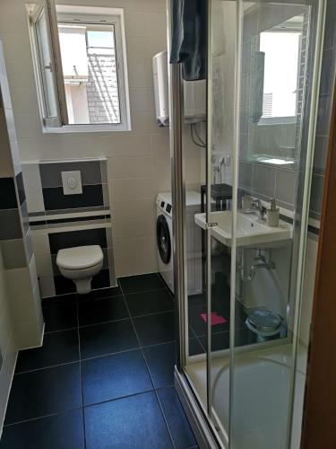 a small bathroom with a toilet and a sink at VillaTea in Murter