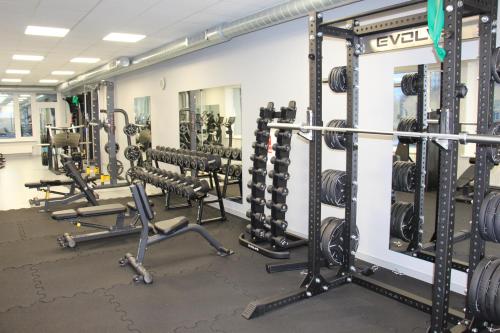 a gym with rows of squat racks and weights at Ignalinos sporto ir pramogų centras in Ignalina