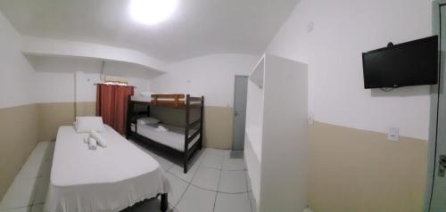 a small room with a bed and a tv at Sol do Centro Pousada in Fortaleza
