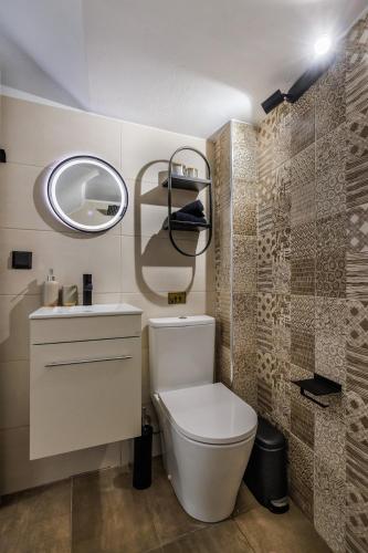a bathroom with a toilet and a sink and a mirror at VRACHOS HOUSE "In the heart of Skopelos Town" in Skopelos Town