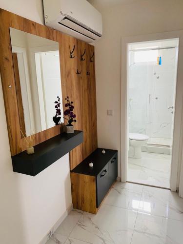 a bathroom with a mirror and a sink and a toilet at D&B Apartment in Brčko