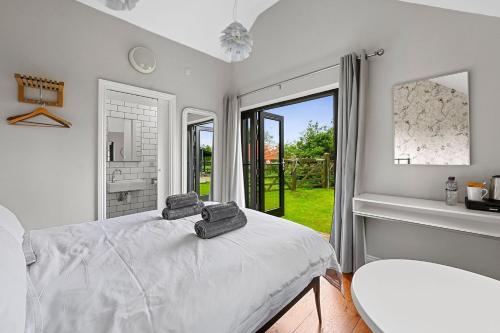 a white bedroom with a bed and a window at The Hare's Field, Wethersfield in Wethersfield