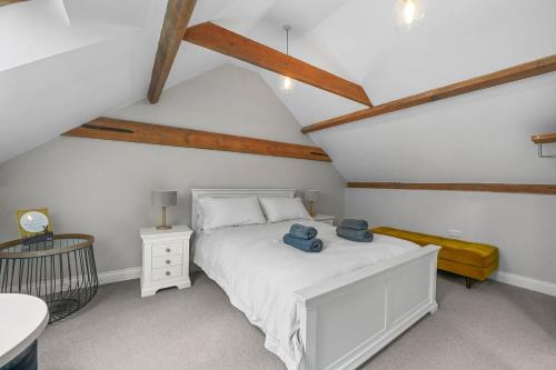 a bedroom with a white bed with blue towels on it at The Hare's Field, Wethersfield in Wethersfield