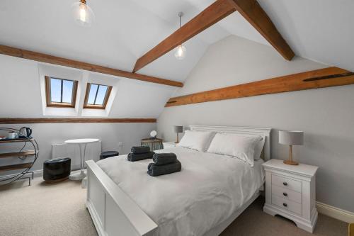 a bedroom with a white bed in a attic at The Hare's Field, Wethersfield in Wethersfield