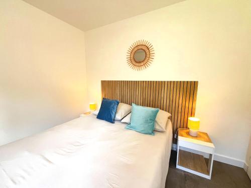 une chambre avec un lit avec des oreillers bleus et un miroir dans l'établissement Chez Eugene, à La Londe-les-Maures