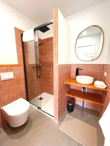 une salle de bain avec toilettes, lavabo et miroir dans l'établissement Chez Eugene, à La Londe-les-Maures