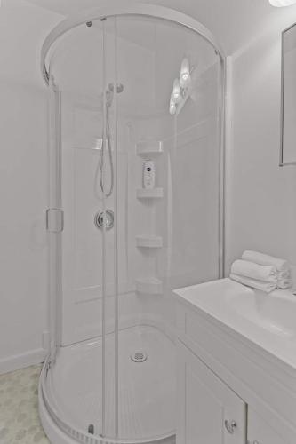 a white bathroom with a shower and a sink at Colorful Charm Jellybean 3BR House In St John's in St. John's