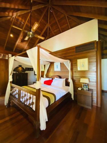 a bedroom with a large bed with a canopy at Hidden Paradise Private Villa 3, Langkawi in Teluk Datai