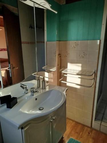 une salle de bain avec un lavabo blanc et un miroir dans l'établissement Maison accueillante à Margerie-Hancourt avec jardin 91 m², à Margerie-Hancourt