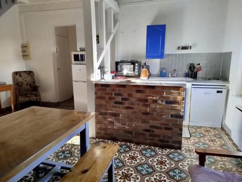 - une cuisine avec un comptoir en briques dans une pièce dans l'établissement Maison accueillante à Margerie-Hancourt avec jardin 91 m², à Margerie-Hancourt