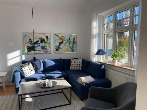 a living room with a blue couch and a table at Villa in the center with Seaview in Nakskov