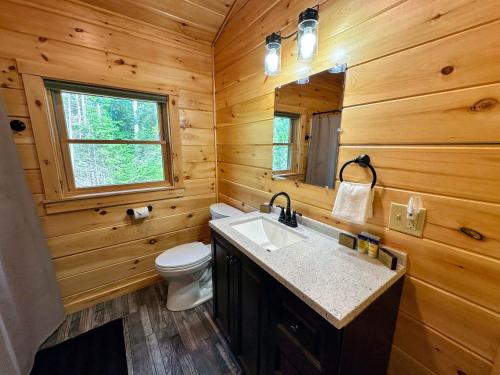 a wooden bathroom with a sink and a toilet at 80PVR Log Home 20min to Bretton Woods AC Hot Tub wifi cable fireplace fire pit in Bethlehem