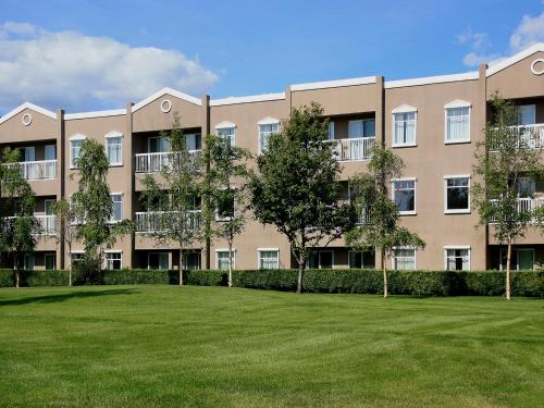 an apartment building with a lawn in front of it at Bear Lodge in Fairbanks