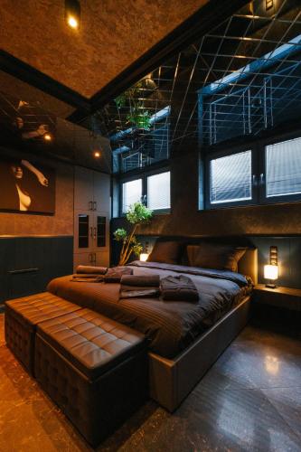 a large bed in a room with windows at Studio Love Ełk explozja zmysłów in Ełk