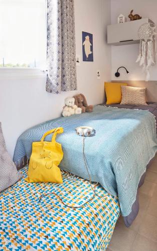 - une chambre dotée d'un lit bleu avec un sac jaune dans l'établissement Camping maeva Escapades Parc Valrose, à La Londe-les-Maures