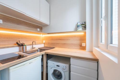 une cuisine avec un évier et une machine à laver dans l'établissement Le Michelet - Studio - Proche Paris, à Saint-Ouen