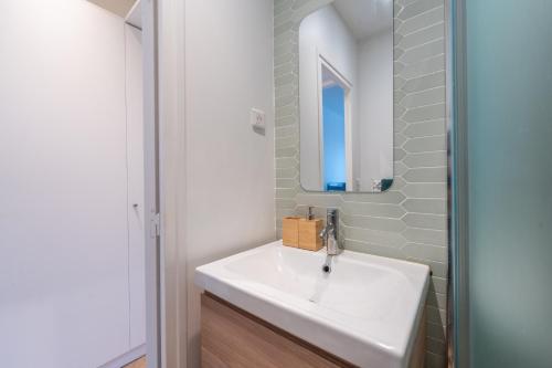 une salle de bain avec un lavabo blanc et un miroir dans l'établissement Le Michelet - Studio - Proche Paris, à Saint-Ouen