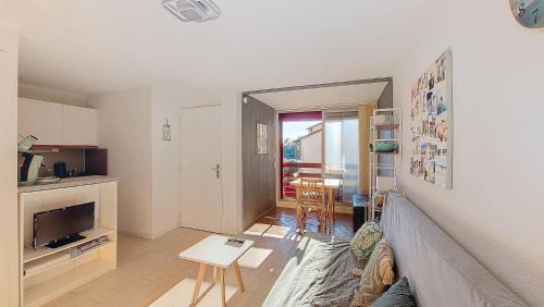 un salon avec un canapé et une table dans l'établissement S-Lac 04-Soustons Appartement 4 personnes dans résidence au bord du lac marin, à Soustons