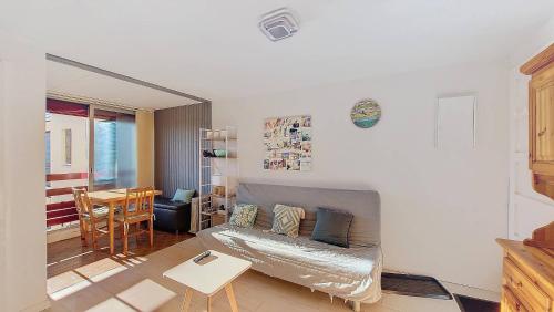 un salon avec un canapé et une table dans l'établissement S-Lac 04-Soustons Appartement 4 personnes dans résidence au bord du lac marin, à Soustons