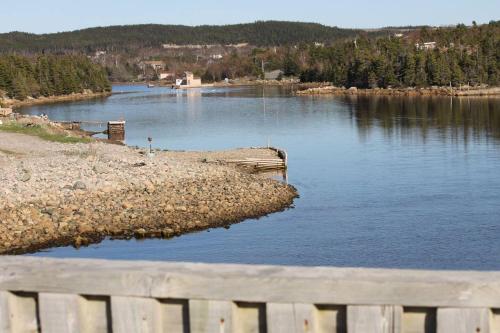 a view of a lake with a wooden fence at Scenic Seal Cove Nature Retreat Hot Tubatv Trail in Holyrood