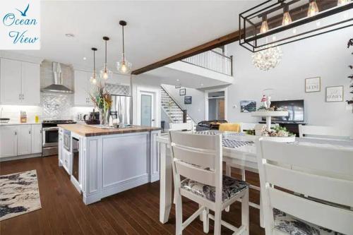 a kitchen with white cabinets and a table and chairs at Scenic Seal Cove Nature Retreat Hot Tubatv Trail in Holyrood