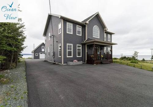 a large house with a driveway in front of it at Scenic Seal Cove Nature Retreat Hot Tubatv Trail in Holyrood