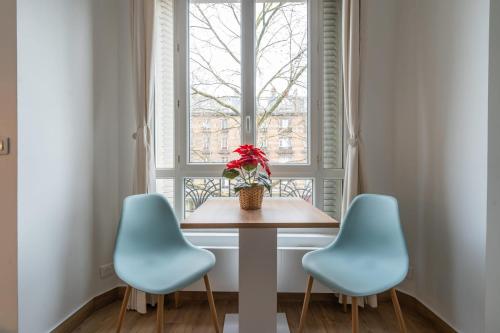 une table et deux chaises devant une fenêtre dans l'établissement Le Michelet - Studio - Proche Paris, à Saint-Ouen