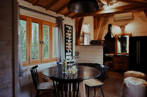 une salle à manger avec une table et des chaises en bois dans l'établissement Châteaux dans les Arbres, à Clottes