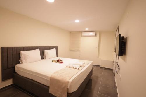 a bedroom with a bed with white sheets and a television at Pekin Spa and Suites in Istanbul