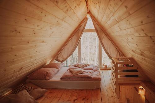 SidzinaにあるDomki pod Halą Krupową - Chata na szlakuの大きな窓付きの木造の部屋のベッド1台分です。