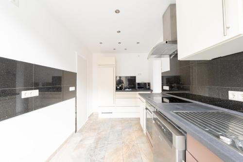 a white kitchen with black and white appliances at Palatium Bad Ems in Bad Ems