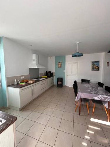 une cuisine et une salle à manger avec une table. dans l'établissement Maison de Famille La Bernerie, à La Bernerie-en-Retz