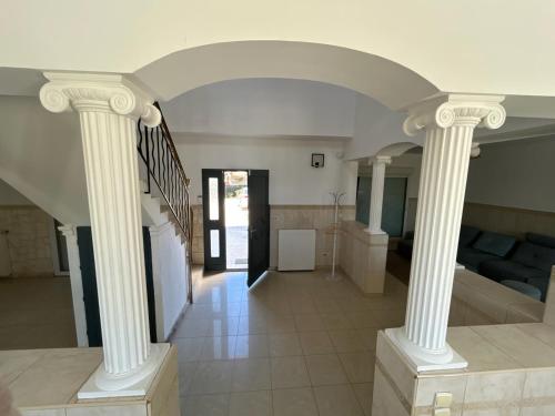 a living room with white columns and a couch at La Maison de Cristina Michael in Blois