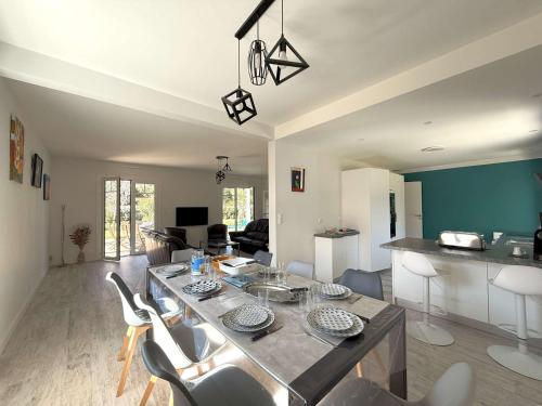 une salle à manger et un salon avec une table et des chaises dans l'établissement Villa rénovée avec jardin à Petit-Piquey - Proche Bassin et Océan, 3 chambres, 2 terrasses, Wi-Fi - FR-1-736-4, à Lège-Cap-Ferret